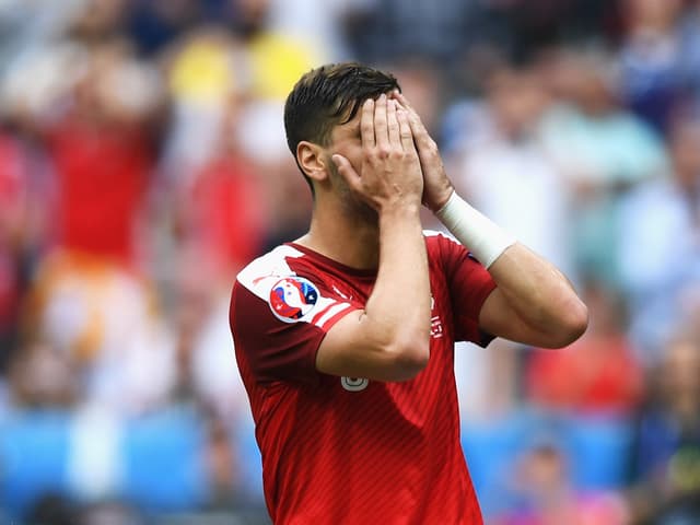 Aleksandar Dragovic verdeckt mit beiden Händen sein Gesicht.