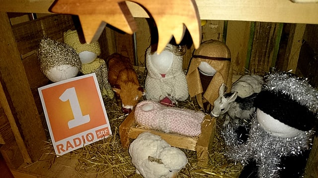 In einer Weihnachtskrippe steht das Radio SRF 1-Logo.