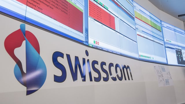 Das Logo der Swisscom steht an einer weissen Wand geschrieben. Das Logo der Swisscom steht an einer weissen Wand geschrieben.