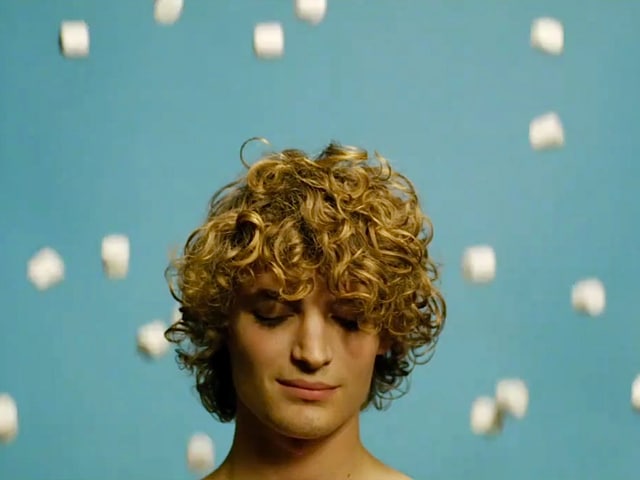 Ein Mann mit blondem Haar. Auf ihn fallen Marshmallows. Ein Mann mit blondem Haar. Auf ihn fallen Marshmallows.