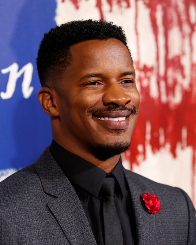 Nate Parker lächelt für die Kamera, im Hintergrund ist das «The Birth of a Nation»-Filmposter. Nate Parker lächelt für die Kamera, im Hintergrund ist das «The Birth of a Nation»-Filmposter.