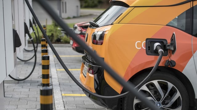 Purtret d'in auto electric ch'è vid tancar vid ina staziun. Purtret d'in auto electric ch'è vid tancar vid ina staziun.