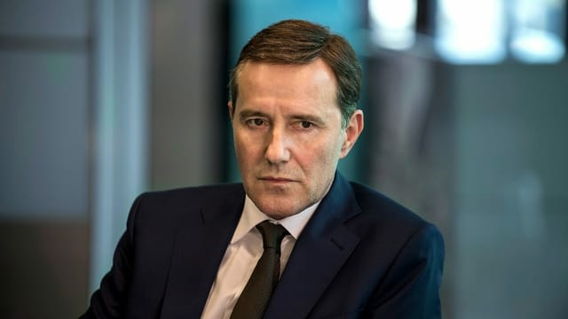 Alexander Maier sitzt geistesabwesend in einem Sitzungszimmer. Alexander Maier sitzt geistesabwesend in einem Sitzungszimmer.