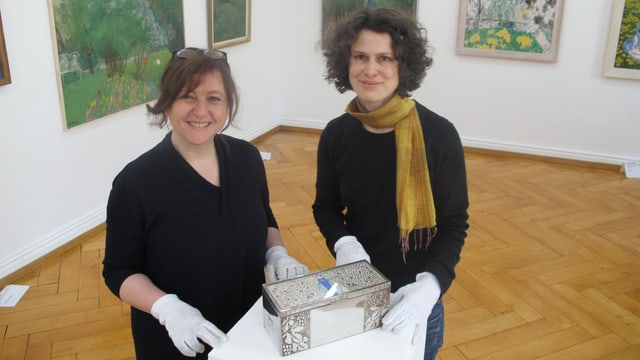 Direktorin und ihre Stellvertreterin arrangieren ein Kunstwerk Direktorin und ihre Stellvertreterin arrangieren ein Kunstwerk