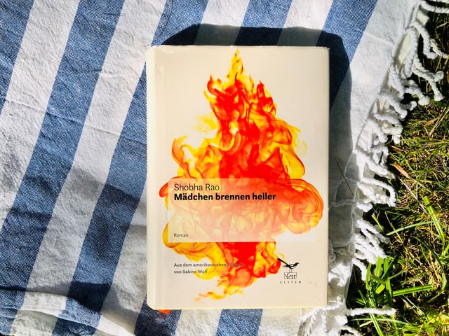 Der Roman «Mädchen brennen heller» von Shobha Rao liegt auf indischem Tuch. Der Roman «Mädchen brennen heller» von Shobha Rao liegt auf indischem Tuch.