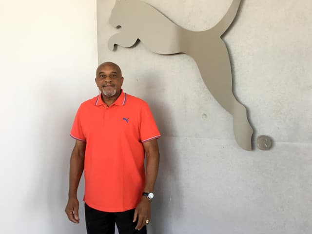 Tommie Smith posiert vor einem Logo. Tommie Smith posiert vor einem Logo.