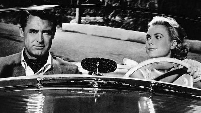 Filmszene aus einem Schwarz-Weiss-Film mit einem Mann und einer Frau in einem Auto Filmszene aus einem Schwarz-Weiss-Film mit einem Mann und einer Frau in einem Auto