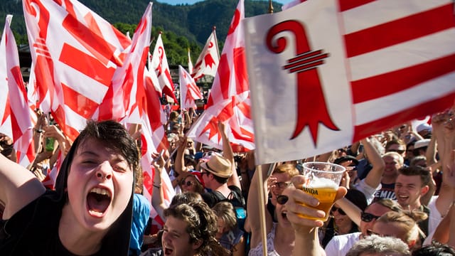 Militanten jubeln mit jurassischen Fahnen Militanten jubeln mit jurassischen Fahnen