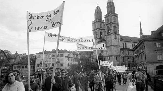 Personen mit Transparenten vor dem Grossmünster. Personen mit Transparenten vor dem Grossmünster.