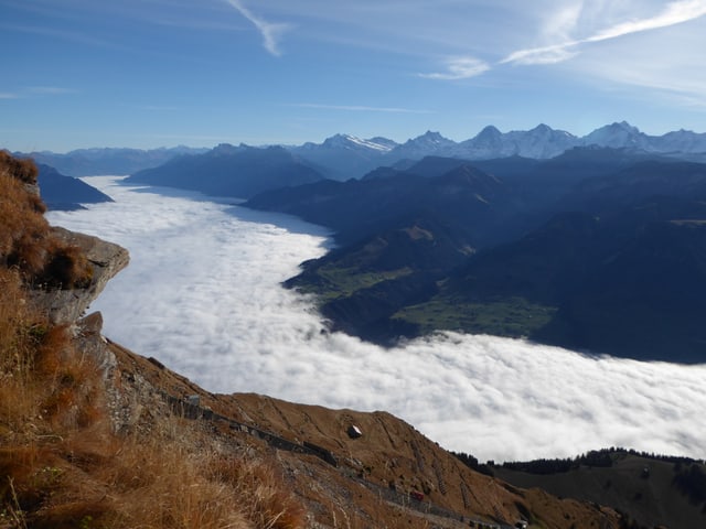 Aussicht von einem Berg in ein nebelgefülltes Tal. Die Nebeloberfläche hat kleine Hügel und Täler. Aussicht von einem Berg in ein nebelgefülltes Tal. Die Nebeloberfläche hat kleine Hügel und Täler.
