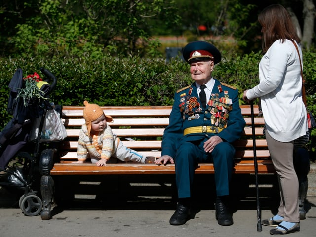 Ein Veteran sitzt auf einer Parkbank.