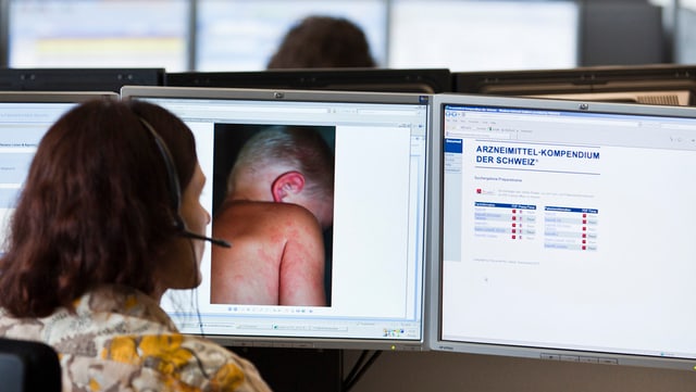 Symbolbild: Eine Ärztin vor dem Computer-Bildschirm in der Medgate-Telefonzentrale, fotografiert von hinten.