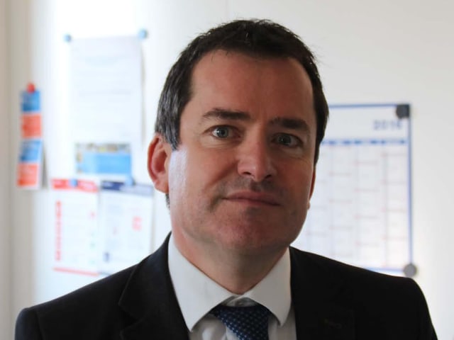 Gilles Giron, ein Mann im Anzug. Gilles Giron, ein Mann im Anzug.