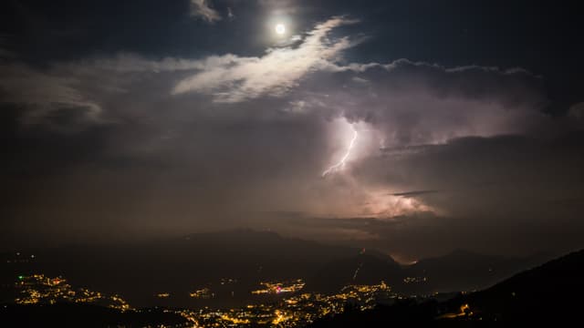 Nächtlicher Blick Richtung Südtessin mit Blitz über der Poebene und Mond über dem Mitteltessin. Nächtlicher Blick Richtung Südtessin mit Blitz über der Poebene und Mond über dem Mitteltessin.