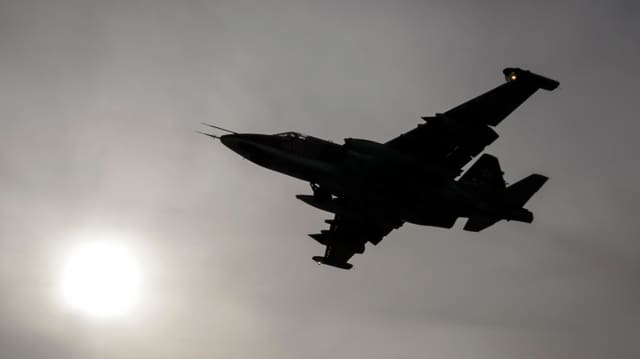 Russisches Kampfflugzeug Sukhoi Su-25 am Himmerl vor der Sonne im Nebel. Russisches Kampfflugzeug Sukhoi Su-25 am Himmerl vor der Sonne im Nebel.