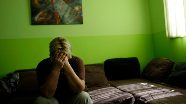 Eine Frau weint im Wohnzimmer. Eine Frau weint im Wohnzimmer.