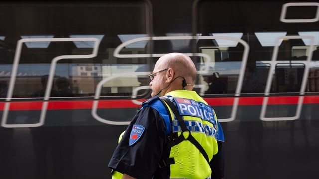 Bahnpolizist vor einem österreichischen Zug Bahnpolizist vor einem österreichischen Zug