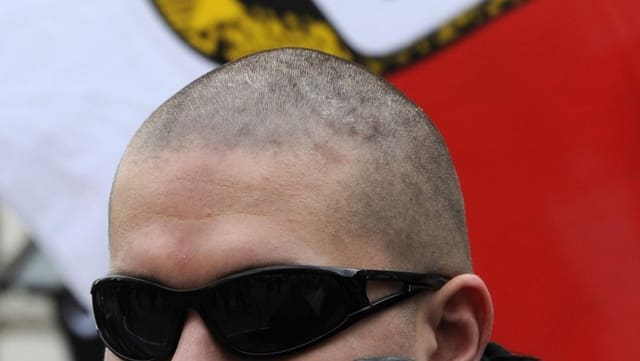 Skinhead vor NPD-Fahne Skinhead vor NPD-Fahne