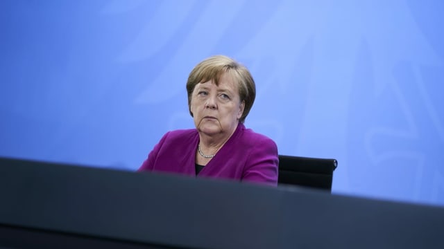 Merkel sitzt an einem Tisch. Merkel sitzt an einem Tisch.