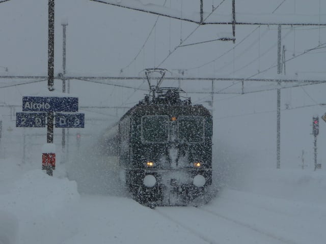 Eine Lokomotive fährt durch den tiefverschneiten Bahnhof in Airolo. Eine Lokomotive fährt durch den tiefverschneiten Bahnhof in Airolo.