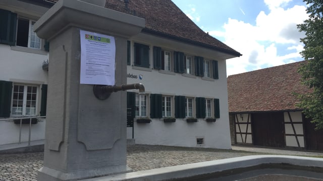 Ein Brunnen, daran ein Zettel mit Anweisungen für das Trinkverbot Ein Brunnen, daran ein Zettel mit Anweisungen für das Trinkverbot
