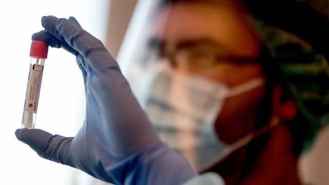 Ein Mann hält einen Corona-Test in der Hand Ein Mann hält einen Corona-Test in der Hand