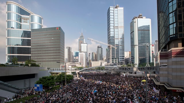 Mit Menschen gefüllte Strasse im Finanzdistrikt von Hongkong, im Hintergrund Bürogebäude, Hochhäuser. Mit Menschen gefüllte Strasse im Finanzdistrikt von Hongkong, im Hintergrund Bürogebäude, Hochhäuser.