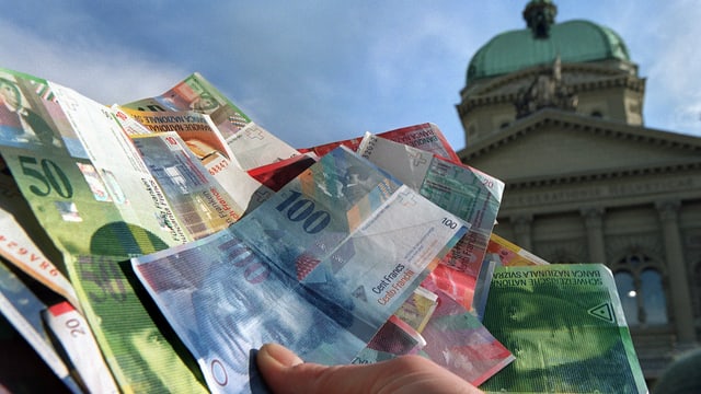 Mann hält Banknoten vor Bundeshaus. Mann hält Banknoten vor Bundeshaus.