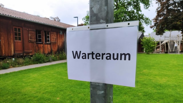 Zettel an Pfosten: Warteraum. Zettel an Pfosten: Warteraum.