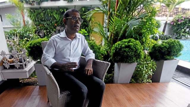 Nasheed sitzt in einem Stuhl und spricht. Nasheed sitzt in einem Stuhl und spricht.