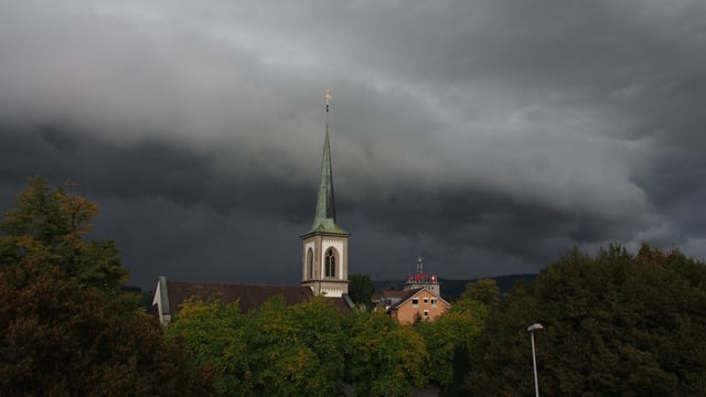 Dunkle Wolkenwalze liegt über der Kirche von Baar. Dunkle Wolkenwalze liegt über der Kirche von Baar.