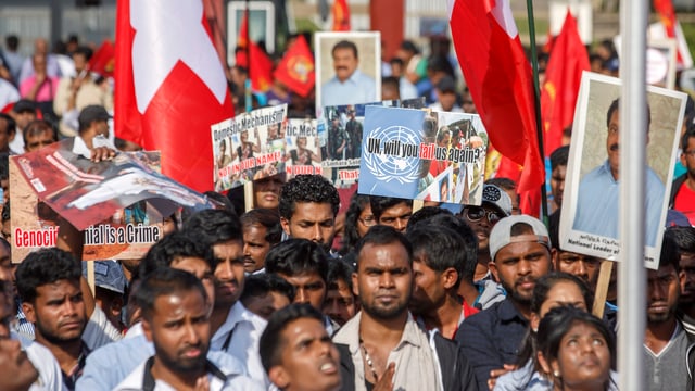 Demonstration von Tamilen, Plakate und Schweizer Fahnen werden in die Höhe gestreckt.