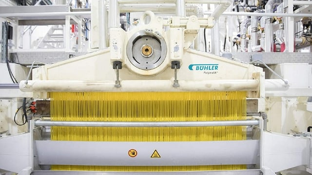 Eine grosse Maschine stellt gleichzeitig tausende von Kilos Spaghetti her. Eine grosse Maschine stellt gleichzeitig tausende von Kilos Spaghetti her.