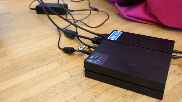 Ein kleines schwarzes Kästchen, an dem Kabel hängen. Ein kleines schwarzes Kästchen, an dem Kabel hängen.