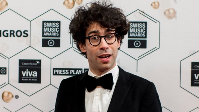 Noah Veraguth postiert im Anzug vor der Fotowand der Swiss Music Awards 2015. 