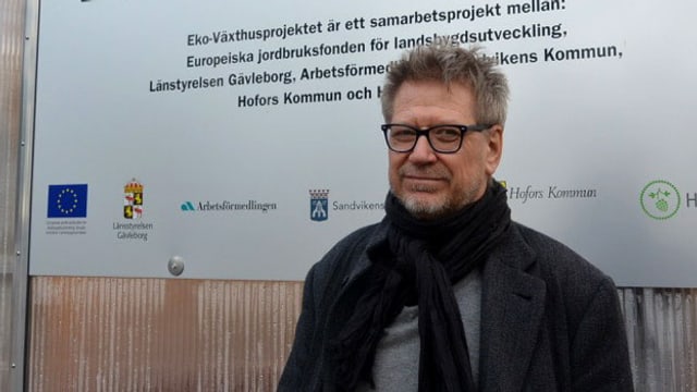 Ein Mann mit Brille steht vor einer Tafel mit der Aufschrift "Eko Växthusprojektet" Ein Mann mit Brille steht vor einer Tafel mit der Aufschrift "Eko Växthusprojektet"