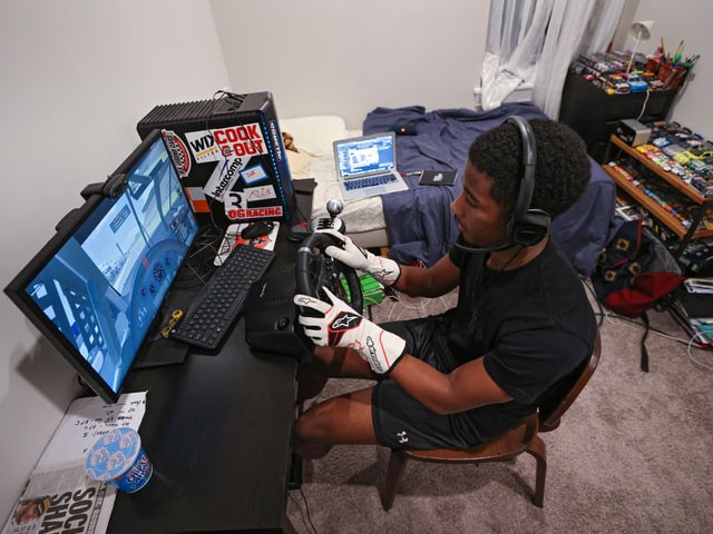 E-Sport geht immer: Wiederum andere versuchen virtuell ihr Glück – wie beispielsweise der NASCAR-Fahrer Rajah Caruth. Die Handschuhe dienen hier übrigens ausnahmsweise einmal einem anderen Zweck.