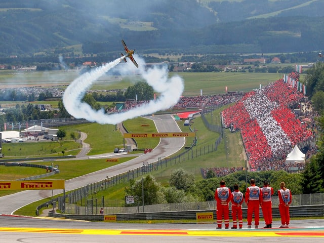 Ein Flugzeug macht einen Looping über der Strecke.
