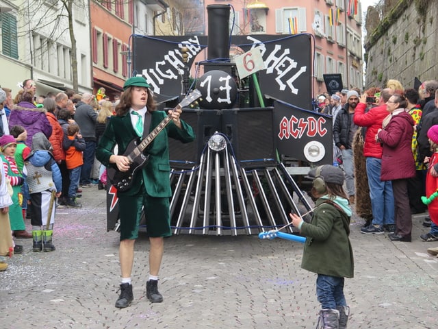 Wagen mit AC/DC-Logo und verkleidetem Gitarristen im Vordergrund