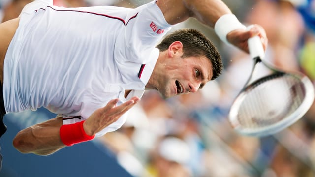 Djokovic beim Aufschlag mit verzerrtem Gesicht. Djokovic beim Aufschlag mit verzerrtem Gesicht.