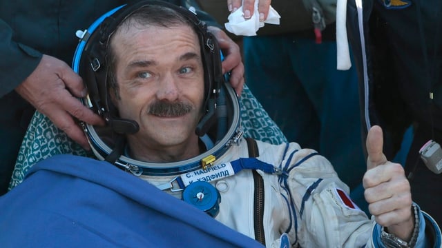 Hadfield nach der Landung mit nach oben gestrecktem Daumen. Hadfield nach der Landung mit nach oben gestrecktem Daumen.