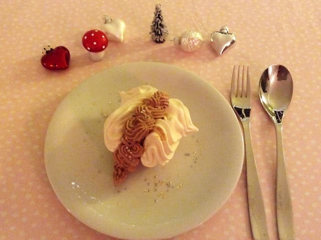 Teller mit Meringues gefüllt mit Schokladencreme und Weihnachtsdekoration Teller mit Meringues gefüllt mit Schokladencreme und Weihnachtsdekoration