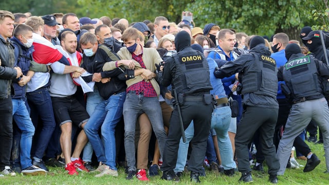 Demonstranten werden von Sicherheitskräften zurückgehalten. Demonstranten werden von Sicherheitskräften zurückgehalten.