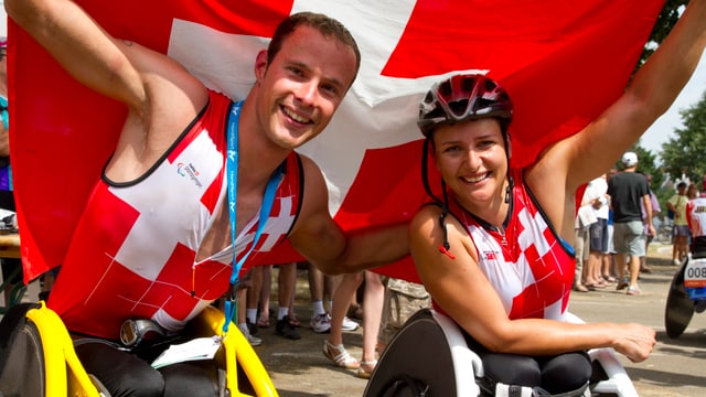 Die Behindertensportler Marcel Hug und Manuela Schär mit einer Schweizer Fahne an der WM.