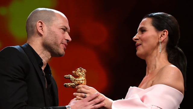 Eine Frau überreicht einem Mann den Goldenen Bären Eine Frau überreicht einem Mann den Goldenen Bären