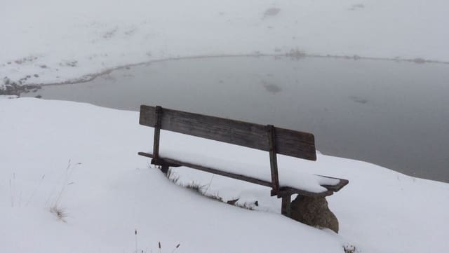Eine Bank an einem See im Schnee Eine Bank an einem See im Schnee