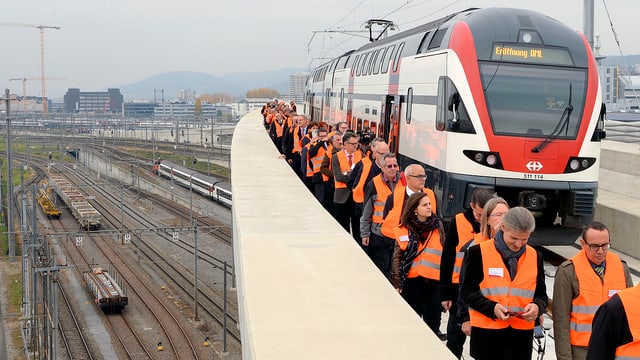 S-Bahn auf einer Brücke stehend, Personen mit Schutzwesten S-Bahn auf einer Brücke stehend, Personen mit Schutzwesten