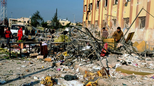 Sanitäter und Helfer in Aleppo suchen vor dem völlig zerstörten Uni-Gebäude nach Verletzten. (keystone) Sanitäter und Helfer in Aleppo suchen vor dem völlig zerstörten Uni-Gebäude nach Verletzten. (keystone)
