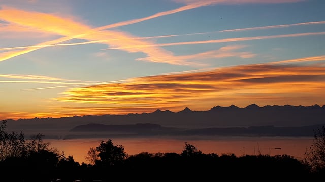 Blick über den Neuenburgersee zu den Alpen, darüber ein paar Schleierwolken. Blick über den Neuenburgersee zu den Alpen, darüber ein paar Schleierwolken.