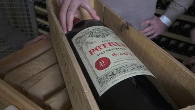 Weinflasche in Holzkiste liegend.